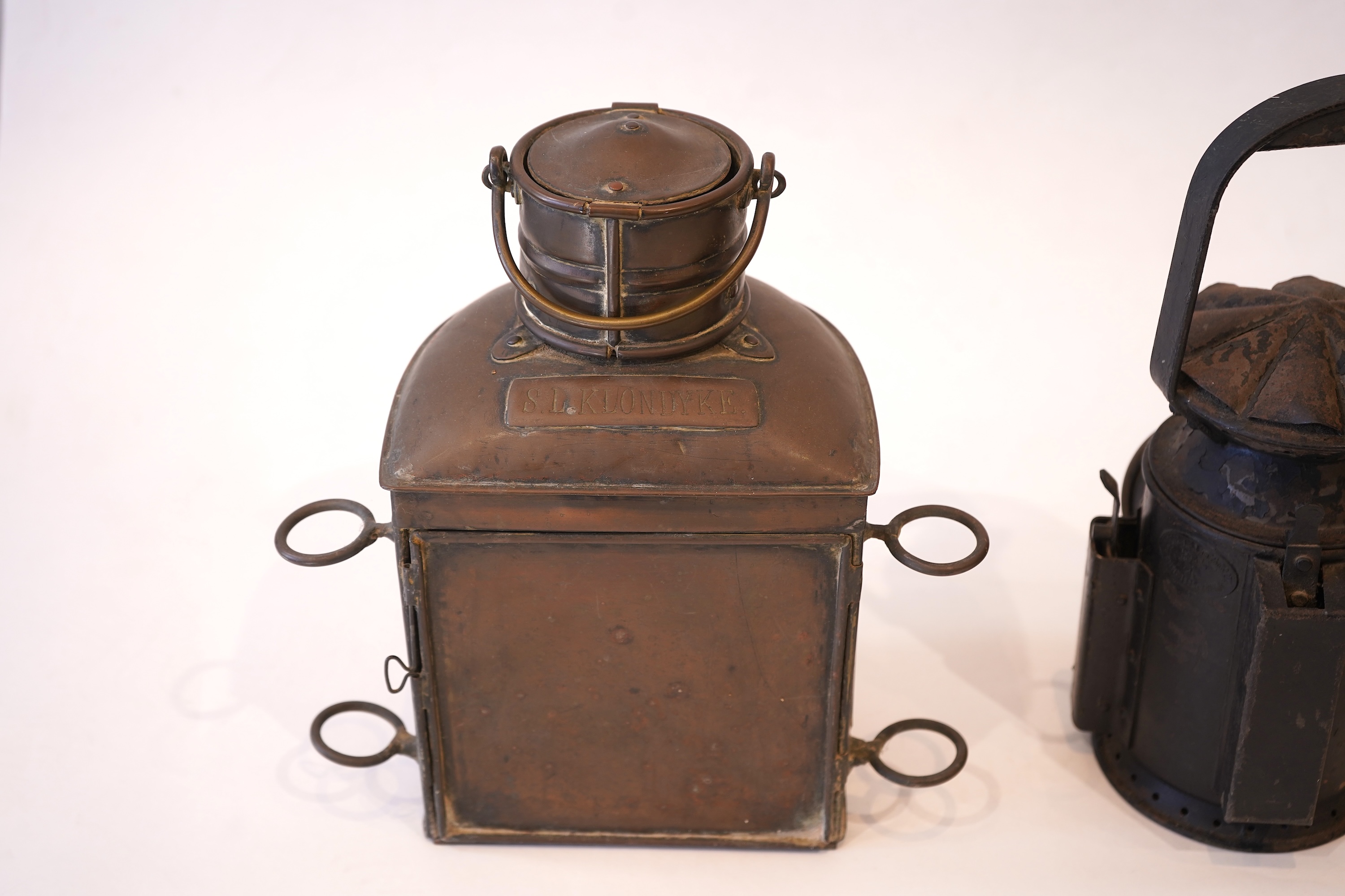 Two black painted railway hand lamps by Pratt & Co. Ltd. Birmingham, both dated 1945, both with burners and reflections, one intended for three colour aspect, with one glass missing, together with a brass ship’s bulkhead